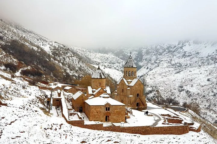 Monastère de Noravank couvert de neige, niché dans un paysage de montagne hivernal